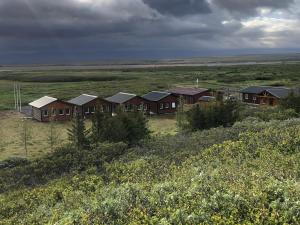 eine Gruppe von Häusern in der Mitte eines Feldes in der Unterkunft Fishing Lodge Hálsakot in Sleðbrjótur