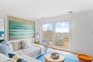 a living room with a couch and a large window at Don't Ditch Your Plains in Montauk