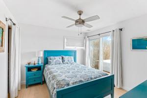 a bedroom with a blue bed and a window at Don't Ditch Your Plains in Montauk