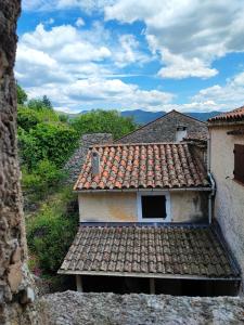 an old house with a tile roof on a hill at Apartment Le 1739 in La Coste
