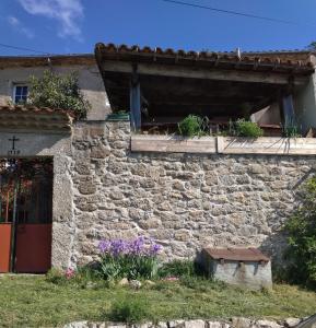 a stone house with flowers in front of it at Apartment Le 1739 in La Coste