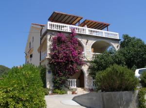 a building with flowers on the side of it at Apartments Kesic in Barbat na Rabu
