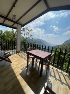 a wooden table on a balcony with a view at Divine View Homestay in Ella