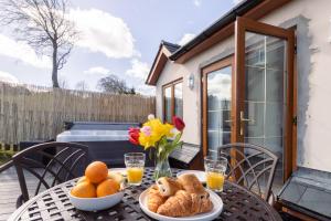 a table with bread and oranges on a patio at Bryn Gerrig View in Pontypool