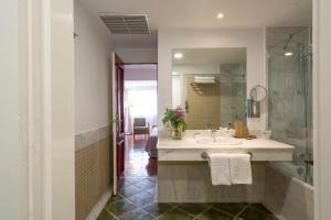 a bathroom with a sink and a shower and a mirror at Parador de Nerja in Nerja