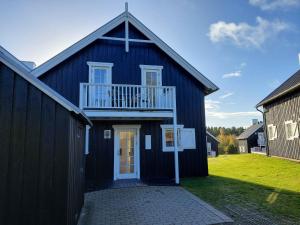 Casa azul con balcón blanco y porche en Beautiful Holiday Home With Spa And Sauna Close To Nature, en Gjern