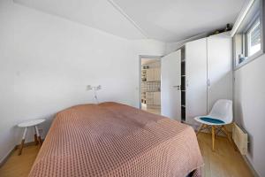 a bedroom with a bed and two chairs in it at Holiday Apartment In Dueodde Holiday Park in Neksø