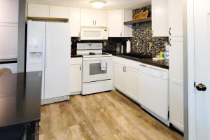 a white kitchen with white appliances and wooden floors at A Bear's Lodge #613 in Sevierville