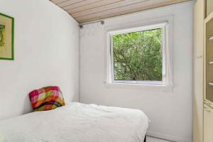Schlafzimmer mit einem Bett und einem Fenster in der Unterkunft Lovely Holiday Home Near The Beach in Vordingborg