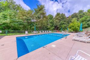 a swimming pool with chairs and a fence around it at A Bear's Lodge #613 in Sevierville