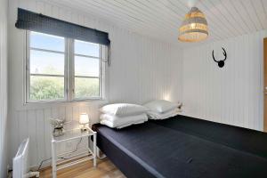 a bedroom with a bed with two pillows and a window at Lovely Cottage For Family With Children And Friends in Kirke-Hyllinge