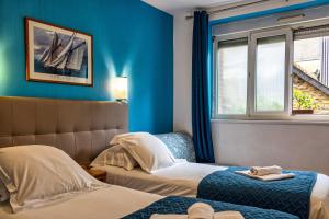 a hotel room with two beds and a window at Hotel La Voilerie Cancale bord de mer in Cancale