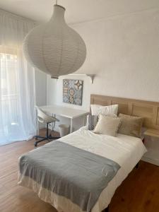 1 dormitorio con cama, escritorio y lámpara grande en Guest house Croqueta Espinardo en Espinardo