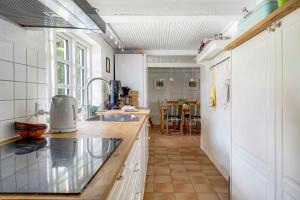 a kitchen with a sink and a counter top at Older Thatched Farmhouse, Approx, 400 Meters From The Water in Ørsted