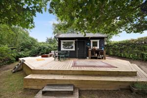 a tiny house sitting on a wooden deck at Charming House With Big Private Terrace in Allinge