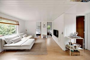 a living room with a white couch and a tv at Charming House With Big Private Terrace in Allinge