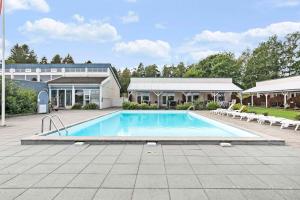 una grande piscina con sedie e un edificio di Holiday Apartment Close To Dueodde Beach a Neksø Altre 10 foto
