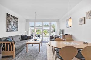 un soggiorno con un divano e un tavolo di Holiday Apartment Close To Dueodde Beach a Neksø