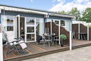 una casa con terrazza arredata con tavolo e sedie di Holiday Apartment Close To Dueodde Beach a Neksø