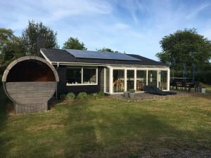 ein Haus mit einem Sonnendach auf einem Hof in der Unterkunft Holiday Home With Sauna And View To The Baltic Sea in Nordborg