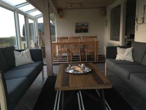 ein Wohnzimmer mit 2 Sofas und einem Tisch in der Unterkunft Holiday Home With Sauna And View To The Baltic Sea in Nordborg