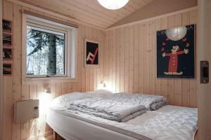 um quarto com uma cama num quarto com uma janela em Lovely Cottage In Fredsskoven, Bjerge Strand, West Zealand em Store Fuglede