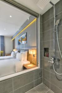 a bedroom with a large bed and a shower at Maris Hotel Nha Trang in Nha Trang