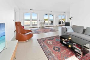 uma sala de estar com um sofá e uma mesa em Holiday Home With Pool And Panoramic View Of The Sea em Asperup