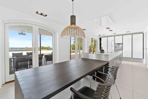 a kitchen with a bar with chairs and a dining room at Holiday Home With Pool And Panoramic View Of The Sea in Asperup