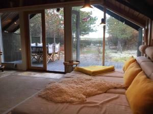 Schlafzimmer mit einem Bett und einem großen Glasfenster in der Unterkunft Enjoy The Nature And Quiteness Of Anholt in Anholt