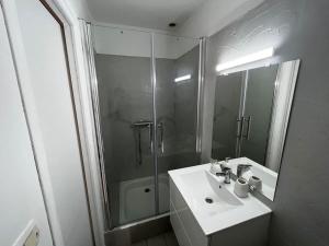 a bathroom with a sink and a shower and a mirror at Le Lyautey - Appart neuf centre-ville Châteaudun in Châteaudun
