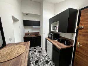 eine kleine Küche mit einem Tisch und einer Mikrowelle in der Unterkunft Le Lyautey - Appart neuf centre-ville Châteaudun in Châteaudun