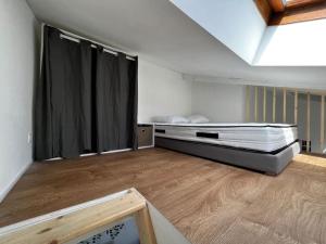 Zimmer mit einem Bett und einem schwarzen Vorhang in der Unterkunft Le Lyautey - Appart neuf centre-ville Châteaudun in Châteaudun