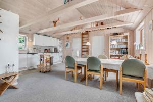 eine Küche mit einem Tisch und Stühlen im Zimmer in der Unterkunft Bright, Spacious And Cozy Cottage, 200 M From The Beach in Hadsund