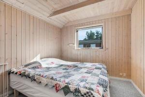 ein Schlafzimmer mit einem Bett in einem Zimmer mit einem Fenster in der Unterkunft Bright, Spacious And Cozy Cottage, 200 M From The Beach in Hadsund