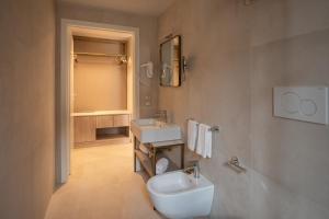 y baño con aseo blanco y lavamanos. en Belduomo, en Taormina