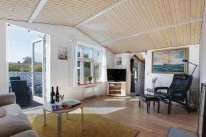 un soggiorno con divano e tavolo di Aahuset Cottage Only 35 Mins From Copenhagen Close To Beach a Kirke-Hyllinge