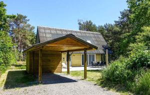 a log cabin with a roof and a patio at Balkalyngen in Neksø