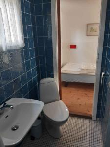 內克瑟的住宿－Klynehuset，浴室配有卫生间、盥洗盆和浴缸。