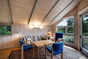 een woonkamer met een tafel en blauwe stoelen bij Welcome To Our Lovely Holiday Home in Gilleleje