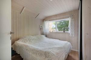 um pequeno quarto com uma cama e uma janela em Newer Holiday Home In Green Surroundings em Jægerspris