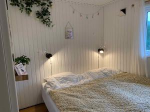 - une chambre avec un lit aux murs blancs et une fenêtre dans l'établissement Peaceful, Idyllic Summerhouse, - Beach And Nature Sanctuary, à Spottrup