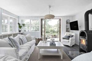 een woonkamer met een witte bank en een tafel bij Luxurious Holiday Home In Tisvildeleje in Tisvildeleje
