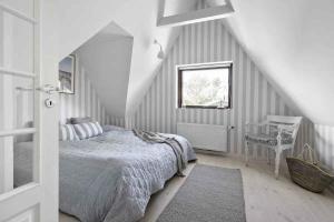 een witte slaapkamer met een bed en een raam bij Luxurious Holiday Home In Tisvildeleje in Tisvildeleje
