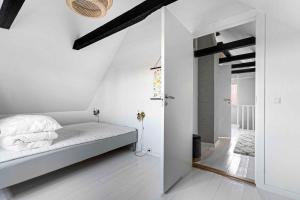 a white bedroom with a bed and a mirror at A Lovely Holiday Home In Quiet, Scenic Surroundings in Rønne