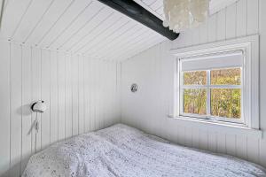 a white bedroom with a bed and a window at Cozy Holiday Home Close To Forest And Beach in Hasle