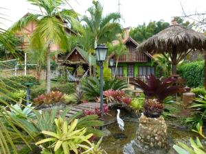 a garden with a pond in front of a house at Hospedaria Bela Vista do Vale in Lumiar