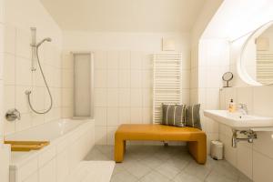 a bathroom with a tub and a sink and a bench at Sound of Music World Appartement in Salzburg