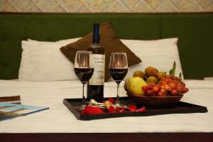 een dienblad met twee glazen wijn en een fruitmand bij Golden Lotus Hotel & Spa in Hanoi