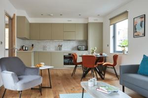 a kitchen and living room with a table and chairs at Hammersmith Mews by Viridian Apartments in London